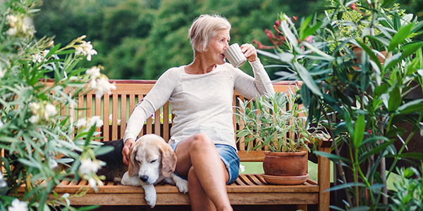 Woman sitting next to dog for brain health.